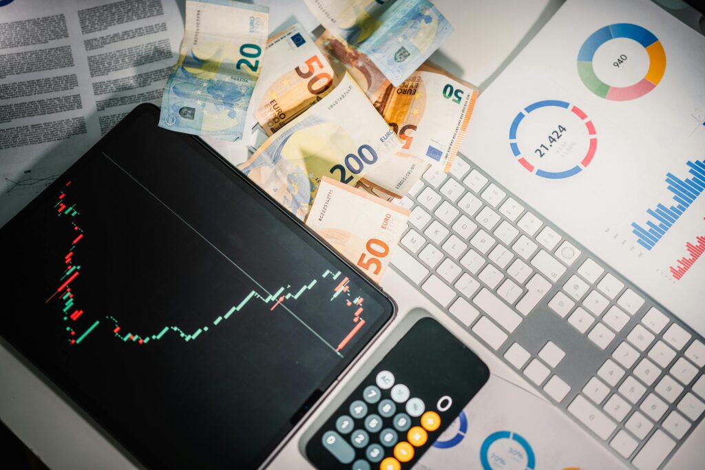 Inicio Overhead view of financial tools with Euro banknotes on a desk showing market trends and graphs.