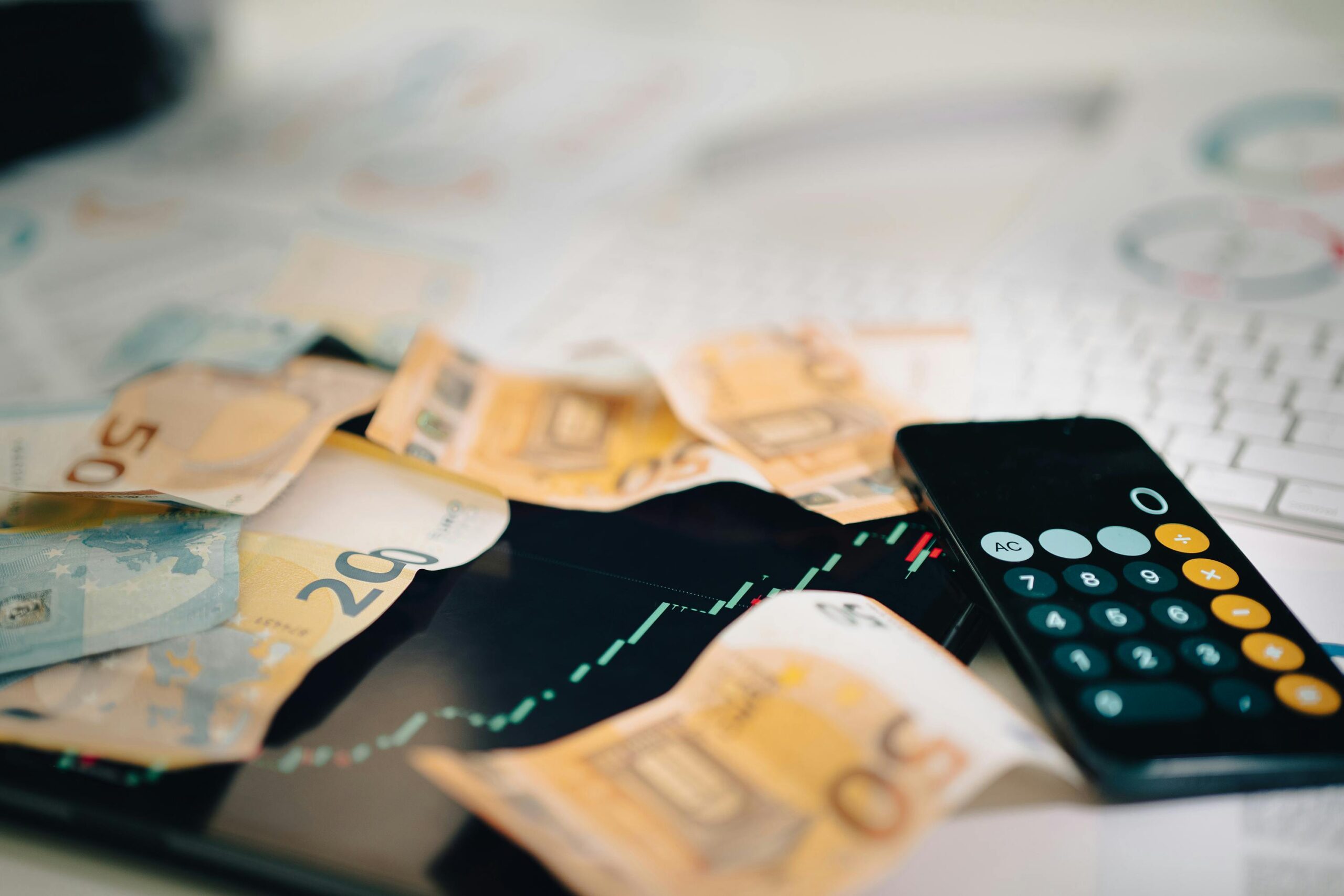 good-vibes Euro banknotes scattered on a trading chart with a calculator, symbolizing finance and analysis.